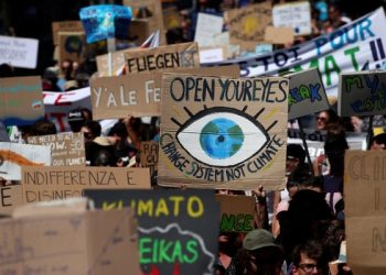 People hold up signs as they take part in a climate strike after the five-day Summer Meeting in Lausanne Europe (SMILE) of the Fridays for Future movement in Lausanne, Switzerland August 9, 2019. REUTERS/Denis Balibouse