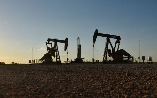 FILE PHOTO: Pump jacks operate in front of a drilling rig in an oil field in Midland, Texas U.S. August 22, 2018. Picture taken August 22, 2018. REUTERS/Nick Oxford/File Photo