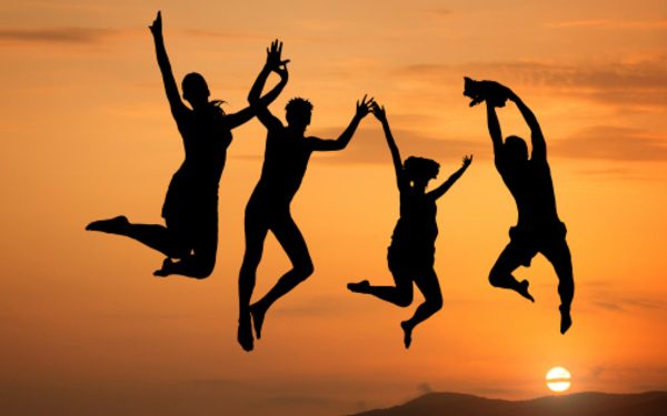 Silhouette of  people jumping at sunset