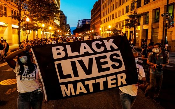 People hold up a Black Lives Matter banner as they march during a demonstration against racial inequality in the aftermath of the death in Minneapolis police custody of George Floyd, in Washington, U.S., June 14, 2020. REUTERS/Erin Scott