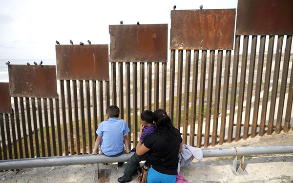 A family looks towards metal bars marking the United States border where it meets the Pacific Ocean Wednesday, March 2, 2016, in Tijuana, Mexico.  Former Mexican President Vicente Fox on Wednesday stood by his comparison of Donald Trump to Adolf Hitler, saying the Republican presidential front-runner “believes in the white supremacy.” Fox is calling on Americans to “wake up” from “this Republican nightmare.” He made the remarks Wednesday in an interview taped for Fox News Channel’s “Hannity.” Trump has angered many Mexicans for his campaign rhetoric denigrating some immigrants as "rapists" who bring crime and drugs to the United States, and his promise to build a wall along the entire US-Mexico border.  (AP Photo/Gregory Bull)