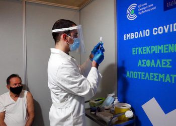 epa09014065 A manwaits to receive a shot of the first dose of the Moderna vaccine against the coronavirus disease (COVID-19), in a new vaccination center in Athens, Greece, 15 February 2021.  EPA-EFE/ORESTIS PANAGIOTOU