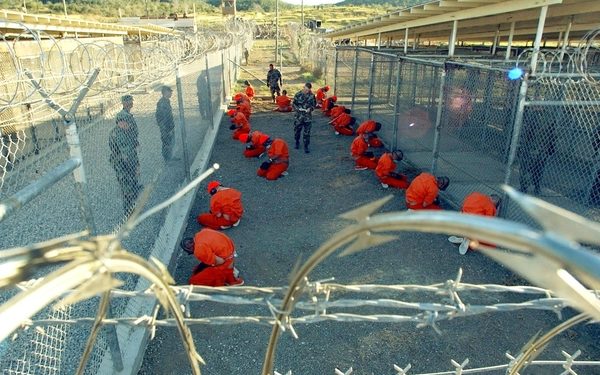 File: US Military Police guard Taliban and al Qaeda detainees in orange jumpsuits in January, 2002