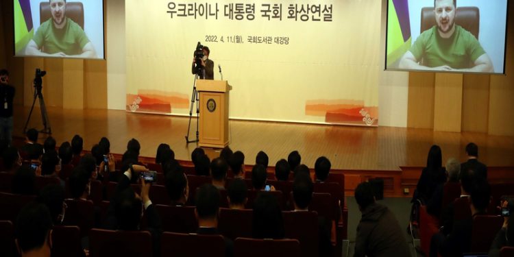epa09884171 Ukrainian President Volodymyr Zelensky (on screen) addresses the National Assembly via video link to Seoul, South Korea, 11 April 2022. Zelensky asked South Korea to provide military hardware support to help his country fight against the Russian aggression.  EPA-EFE/YONHAP / POOL SOUTH KOREA OUT