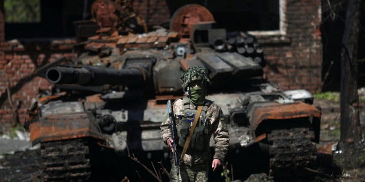 Украински војник до уништен руски тенк во близина на Харкив. Фото: REUTERS/Ricardo Moraes