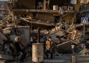 Луѓето седат покрај уништената куќа по земјотресот во Антакија, југоисточна Турција / Фото: АП