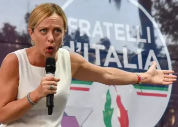 Џорџа Мелони со транспарент на нејзината партија Браќа од Италија - многумина истакнаа дека симболот на пламенот се враќа на фашистичкото потекло на партијатаИпа/Сипа /Пјеро ТЕНАГЛИ