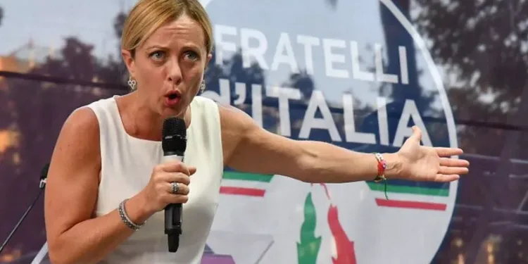 Џорџа Мелони со транспарент на нејзината партија Браќа од Италија - многумина истакнаа дека симболот на пламенот се враќа на фашистичкото потекло на партијатаИпа/Сипа /Пјеро ТЕНАГЛИ