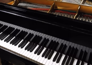 Classical black grand piano with keyboard in foreground. More piano pictures...